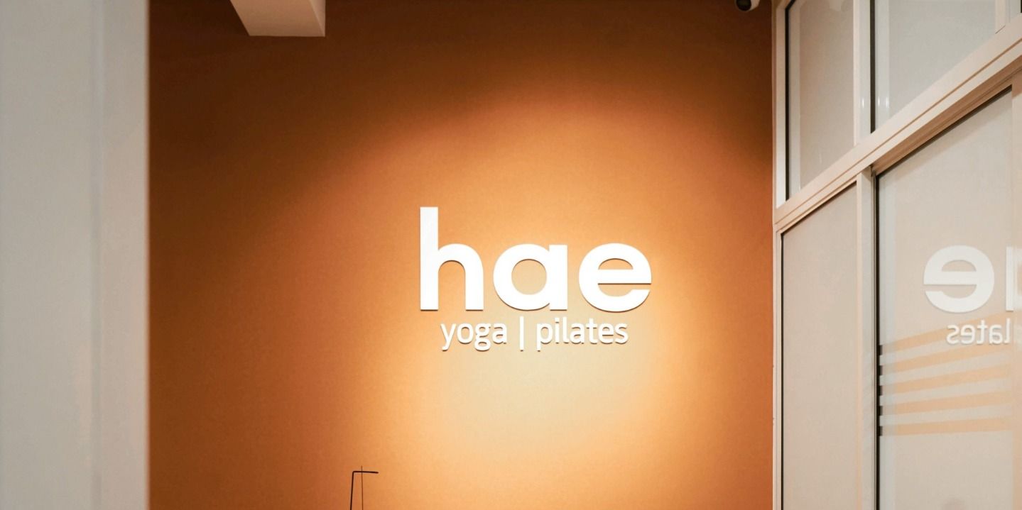 Backlit hae yoga pilates sign glowing on the studio wall